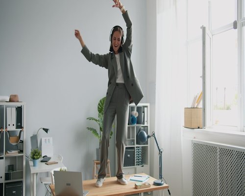 A person standing and stretching near an office desk